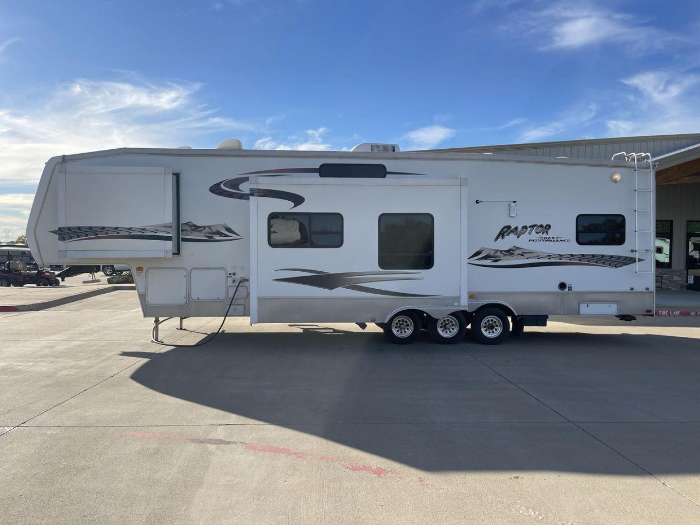 2006 KEYSTONE RAPTOR (4YDF361376M) , Length: 37.58 ft | Dry Weight: 11,615 lbs | Slides: 2 transmission, located at 4319 N Main St, Cleburne, TX, 76033, (817) 678-5133, 32.385960, -97.391212 - The 2016 Keystone Raptor RP3612 is a fifth-wheel toy hauler with a bold and functional exterior. It features a white body with stylish decals that include swooping lines and mountain graphics, giving it a sporty and adventurous look. The RV has three axles, offering stability and support for its lar - Photo#23