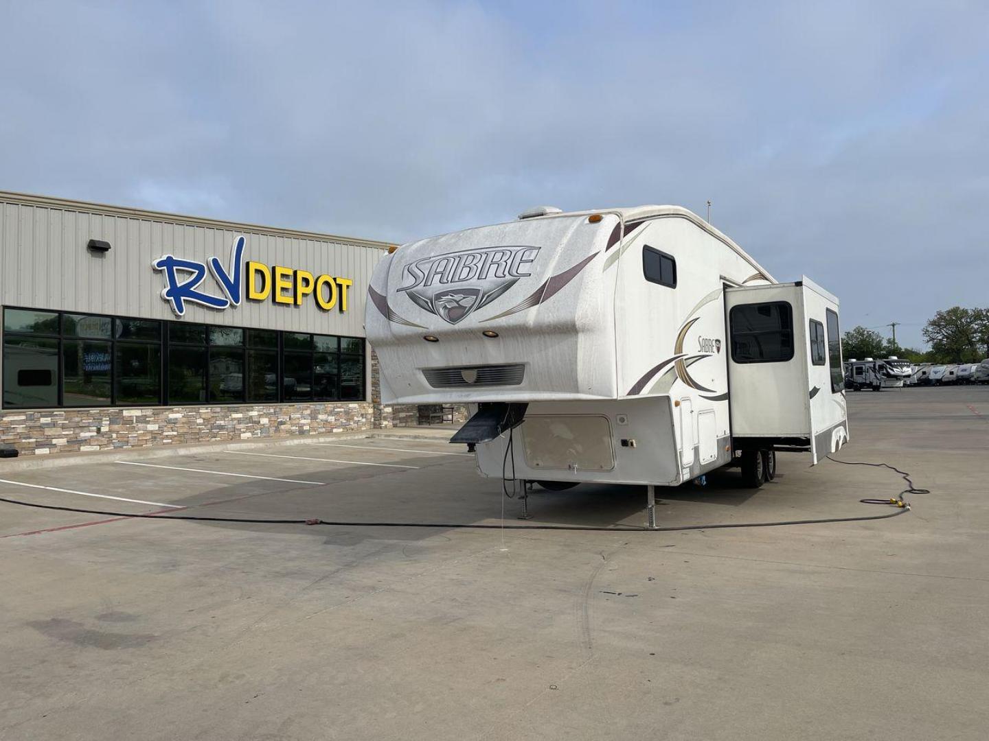 2010 WHITE FOREST RIVER SABRE 32QBDS - (4X4FSRH28A3) , Length: 35 ft. | Dry Weight: 9,235 lbs. | Gross Weight: 11,682 lbs. | Slides: 2 transmission, located at 4319 N Main St, Cleburne, TX, 76033, (817) 678-5133, 32.385960, -97.391212 - This 2010 Forest River Sabre 32QBDS has a very family-friendly floor plan. It measures 35 ft in length and has a dry weight of 9,235 lbs. The gross weight is 11,682 lbs, and it has two slides. The door leads you to the central living and kitchen area. The living area comes with an entertainment cent - Photo#0