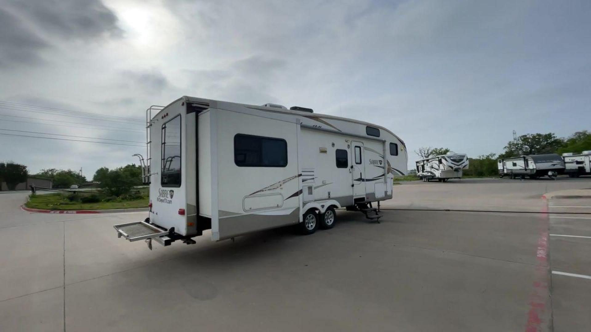 2010 WHITE FOREST RIVER SABRE 32QBDS - (4X4FSRH28A3) , Length: 35 ft. | Dry Weight: 9,235 lbs. | Gross Weight: 11,682 lbs. | Slides: 2 transmission, located at 4319 N Main St, Cleburne, TX, 76033, (817) 678-5133, 32.385960, -97.391212 - This 2010 Forest River Sabre 32QBDS has a very family-friendly floor plan. It measures 35 ft in length and has a dry weight of 9,235 lbs. The gross weight is 11,682 lbs, and it has two slides. The door leads you to the central living and kitchen area. The living area comes with an entertainment cent - Photo#1