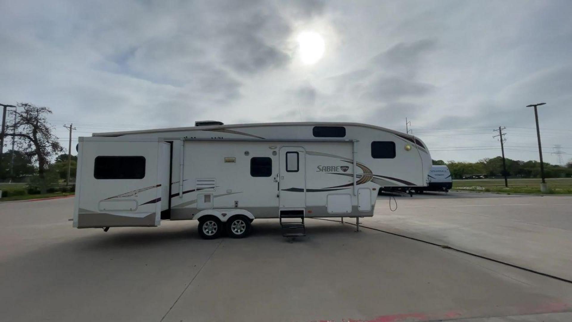 2010 WHITE FOREST RIVER SABRE 32QBDS - (4X4FSRH28A3) , Length: 35 ft. | Dry Weight: 9,235 lbs. | Gross Weight: 11,682 lbs. | Slides: 2 transmission, located at 4319 N Main St, Cleburne, TX, 76033, (817) 678-5133, 32.385960, -97.391212 - This 2010 Forest River Sabre 32QBDS has a very family-friendly floor plan. It measures 35 ft in length and has a dry weight of 9,235 lbs. The gross weight is 11,682 lbs, and it has two slides. The door leads you to the central living and kitchen area. The living area comes with an entertainment cent - Photo#2