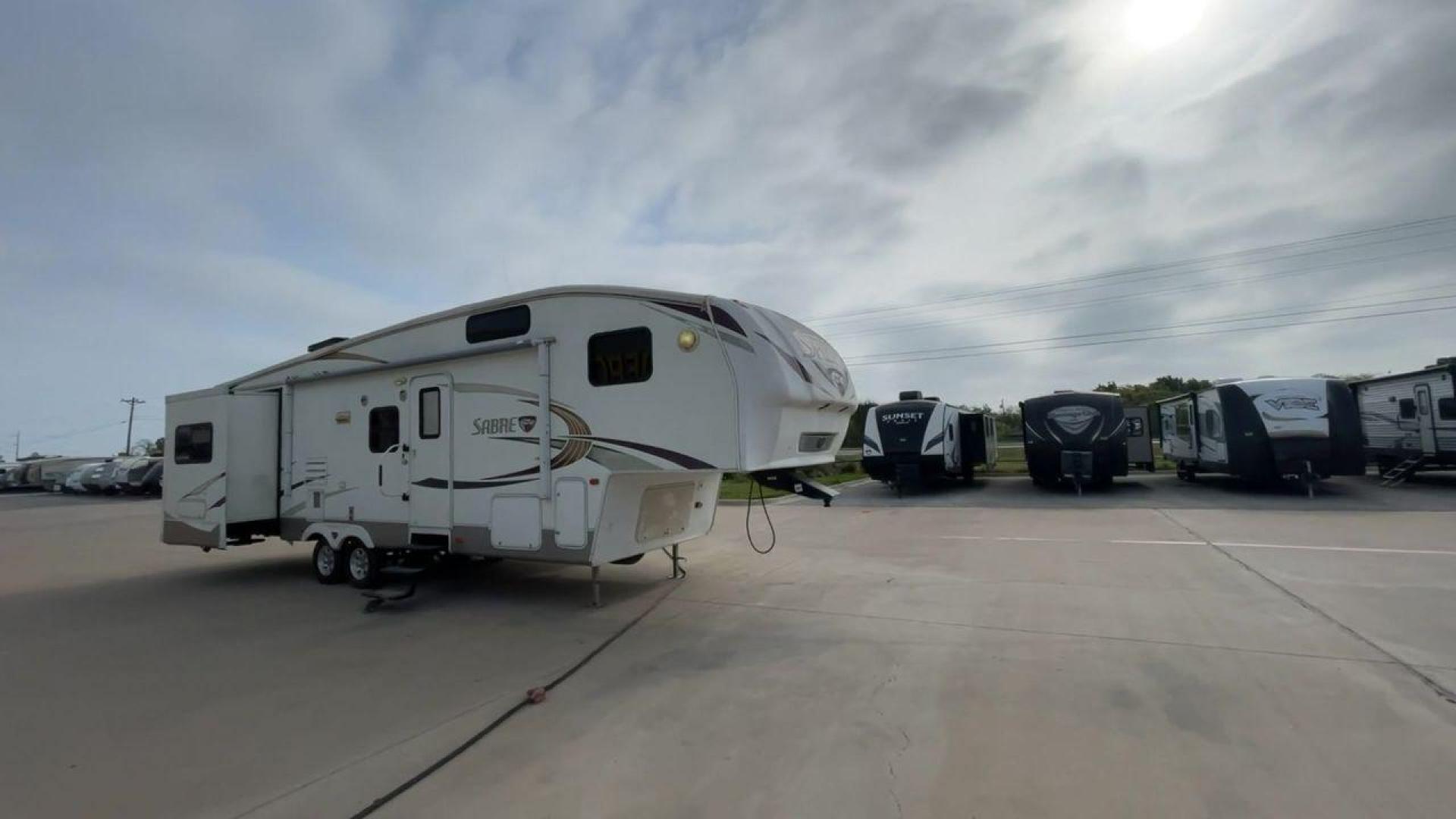 2010 WHITE FOREST RIVER SABRE 32QBDS - (4X4FSRH28A3) , Length: 35 ft. | Dry Weight: 9,235 lbs. | Gross Weight: 11,682 lbs. | Slides: 2 transmission, located at 4319 N Main St, Cleburne, TX, 76033, (817) 678-5133, 32.385960, -97.391212 - This 2010 Forest River Sabre 32QBDS has a very family-friendly floor plan. It measures 35 ft in length and has a dry weight of 9,235 lbs. The gross weight is 11,682 lbs, and it has two slides. The door leads you to the central living and kitchen area. The living area comes with an entertainment cent - Photo#3