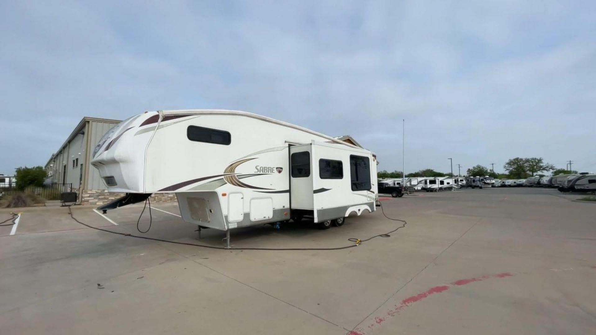 2010 WHITE FOREST RIVER SABRE 32QBDS - (4X4FSRH28A3) , Length: 35 ft. | Dry Weight: 9,235 lbs. | Gross Weight: 11,682 lbs. | Slides: 2 transmission, located at 4319 N Main St, Cleburne, TX, 76033, (817) 678-5133, 32.385960, -97.391212 - This 2010 Forest River Sabre 32QBDS has a very family-friendly floor plan. It measures 35 ft in length and has a dry weight of 9,235 lbs. The gross weight is 11,682 lbs, and it has two slides. The door leads you to the central living and kitchen area. The living area comes with an entertainment cent - Photo#5