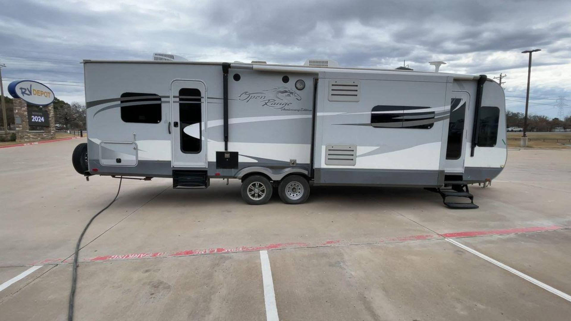 2013 GRAY HEARTLAND OPEN RANGE 288FLR - (5XMTL3726D2) , Length: 33.5 ft | Dry Weight: 7,480 lbs. | Gross Weight: 9,800 lbs. | Slides: 3 transmission, located at 4319 N Main St, Cleburne, TX, 76033, (817) 678-5133, 32.385960, -97.391212 - The 2013 Heartland Open Range 288FLR focuses on spacious living and thoughtful design. This travel trailer offers a luxurious home on wheels for those seeking both comfort and adventure. Step into the RV and be welcomed by the innovative front living room layout. This unique design features a spacio - Photo#2