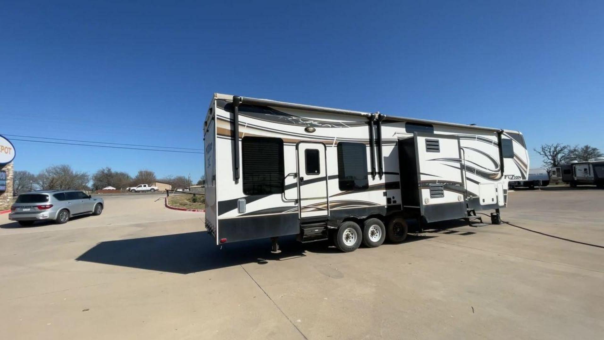 2013 WHITE KEYSTONE FUZION FZ399 - (4YDF39923DF) , Length: 41 ft. | Dry Weight: 13,880 lbs. | Gross Weight: 18,000 lbs. | Slides: 3 transmission, located at 4319 N Main St, Cleburne, TX, 76033, (817) 678-5133, 32.385960, -97.391212 - The 2013 Keystone Fuzion FZ399 toy hauler measures 41 ft in length, 8.5 ft in width, and 13.25 ft in height. It has a dry weight of 13,880 lbs with a payload capacity of 4,120 lbs. The GVWR is 18,000 lbs and has a hitch weight of 3,560 lbs. This has a triple axle and triple slide with one 20 ft powe - Photo#1