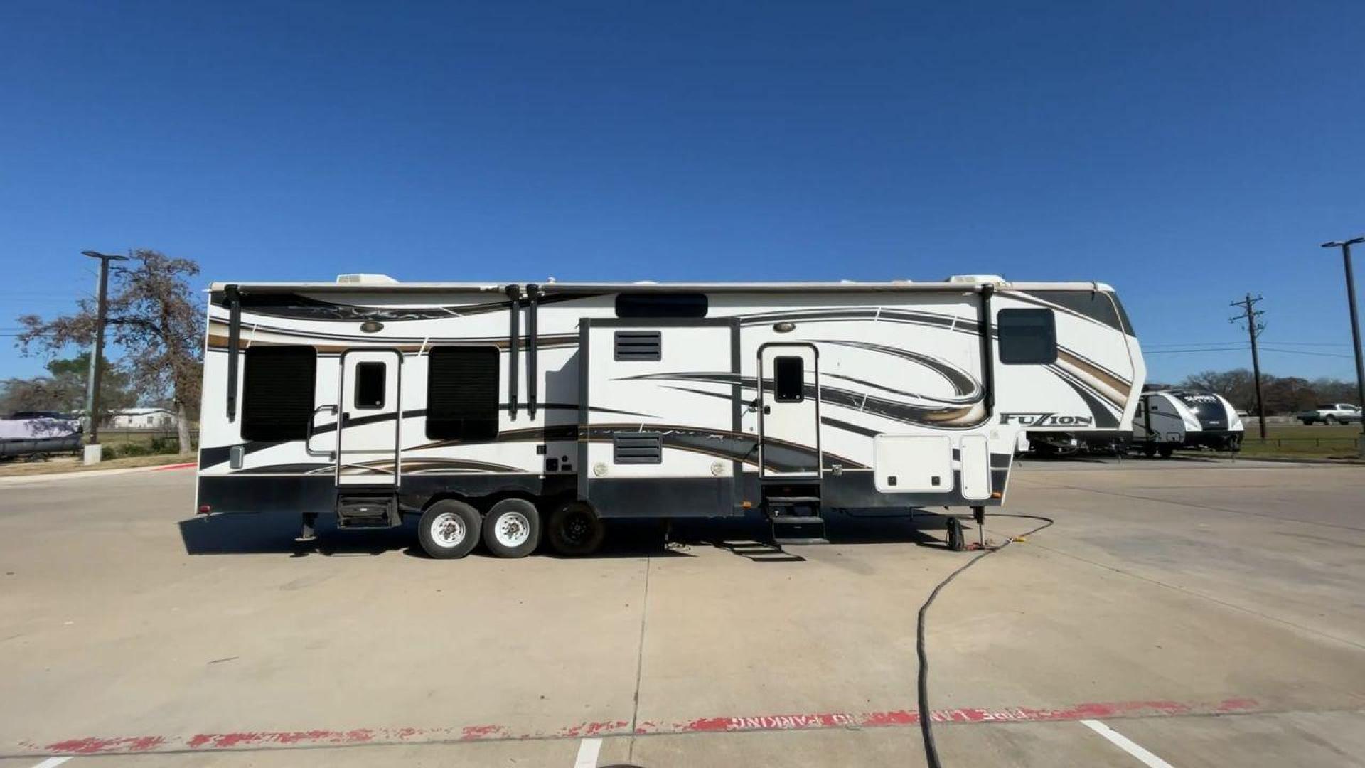 2013 WHITE KEYSTONE FUZION FZ399 - (4YDF39923DF) , Length: 41 ft. | Dry Weight: 13,880 lbs. | Gross Weight: 18,000 lbs. | Slides: 3 transmission, located at 4319 N Main St, Cleburne, TX, 76033, (817) 678-5133, 32.385960, -97.391212 - The 2013 Keystone Fuzion FZ399 toy hauler measures 41 ft in length, 8.5 ft in width, and 13.25 ft in height. It has a dry weight of 13,880 lbs with a payload capacity of 4,120 lbs. The GVWR is 18,000 lbs and has a hitch weight of 3,560 lbs. This has a triple axle and triple slide with one 20 ft powe - Photo#2