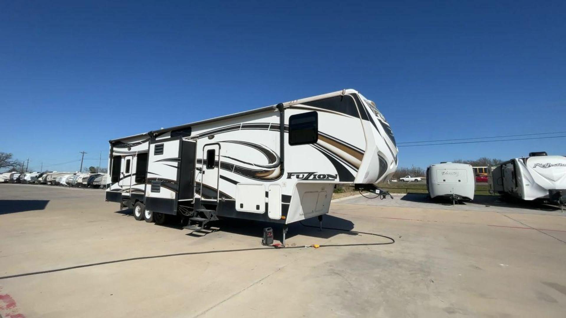 2013 WHITE KEYSTONE FUZION FZ399 - (4YDF39923DF) , Length: 41 ft. | Dry Weight: 13,880 lbs. | Gross Weight: 18,000 lbs. | Slides: 3 transmission, located at 4319 N Main St, Cleburne, TX, 76033, (817) 678-5133, 32.385960, -97.391212 - The 2013 Keystone Fuzion FZ399 toy hauler measures 41 ft in length, 8.5 ft in width, and 13.25 ft in height. It has a dry weight of 13,880 lbs with a payload capacity of 4,120 lbs. The GVWR is 18,000 lbs and has a hitch weight of 3,560 lbs. This has a triple axle and triple slide with one 20 ft powe - Photo#3