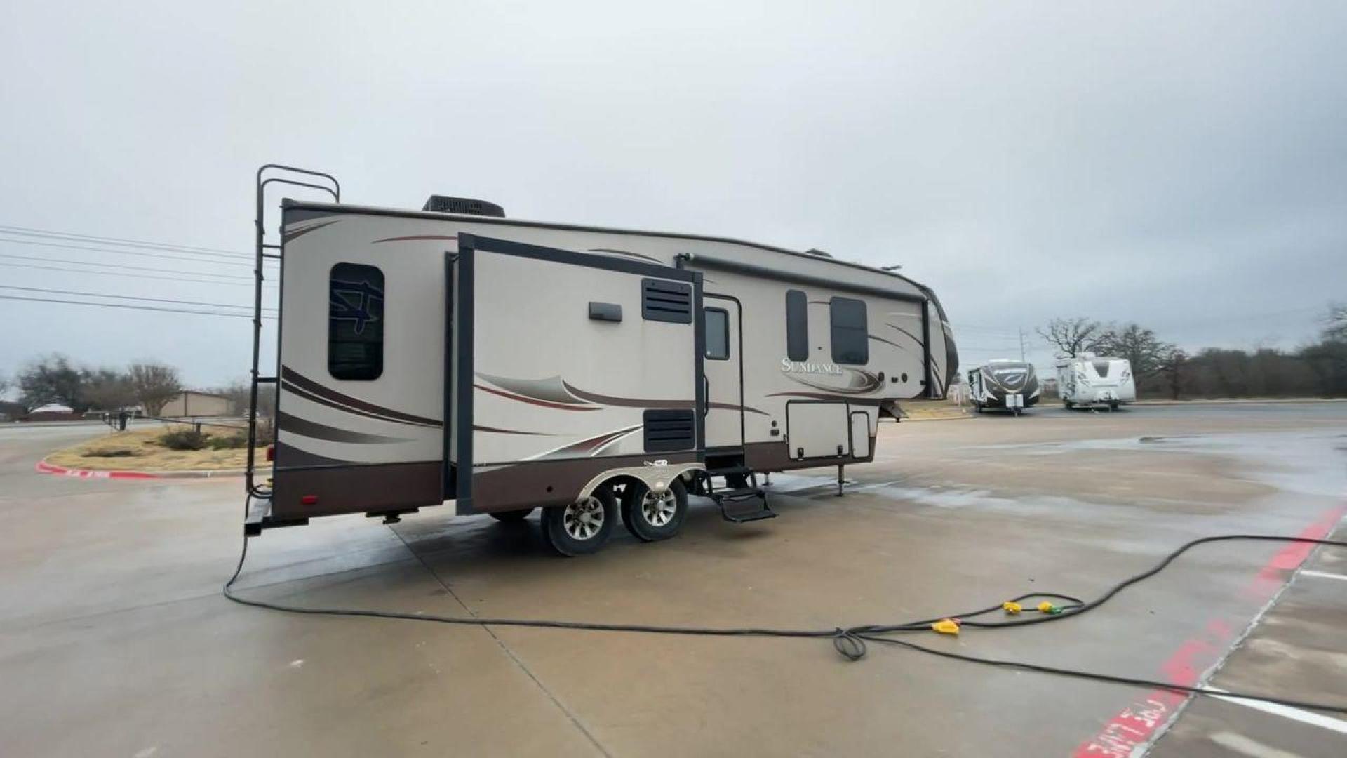 2014 TAN SUNDANCE 2880RLT (5SFSG3320EE) , Length: 32.2 ft. | Dry Weight: 9,750 lbs. | Gross Weight: 13,800 lbs. | Slides: 3 transmission, located at 4319 N Main St, Cleburne, TX, 76033, (817) 678-5133, 32.385960, -97.391212 - This 2014 Sundance Fifth Wheel is just over 32 feet long and 8 feet wide. It has a GVWR of 13,800 lbs and a hitch weight of 2,220 lbs. The exterior of this fifth wheel is a stylish grey with brown, white, and beige decals. This model also has three slides and a 16-foot power-retractable awning. The - Photo#1