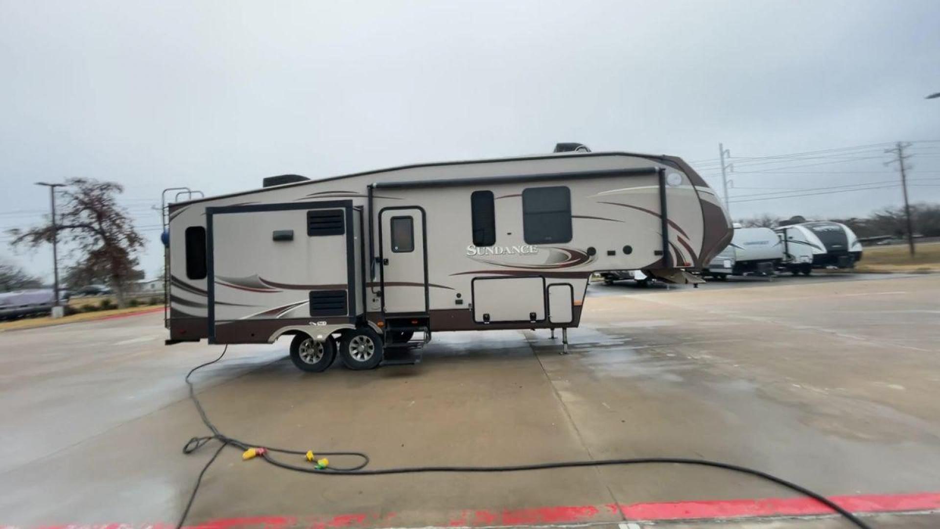 2014 TAN SUNDANCE 2880RLT (5SFSG3320EE) , Length: 32.2 ft. | Dry Weight: 9,750 lbs. | Gross Weight: 13,800 lbs. | Slides: 3 transmission, located at 4319 N Main St, Cleburne, TX, 76033, (817) 678-5133, 32.385960, -97.391212 - This 2014 Sundance Fifth Wheel is just over 32 feet long and 8 feet wide. It has a GVWR of 13,800 lbs and a hitch weight of 2,220 lbs. The exterior of this fifth wheel is a stylish grey with brown, white, and beige decals. This model also has three slides and a 16-foot power-retractable awning. The - Photo#2