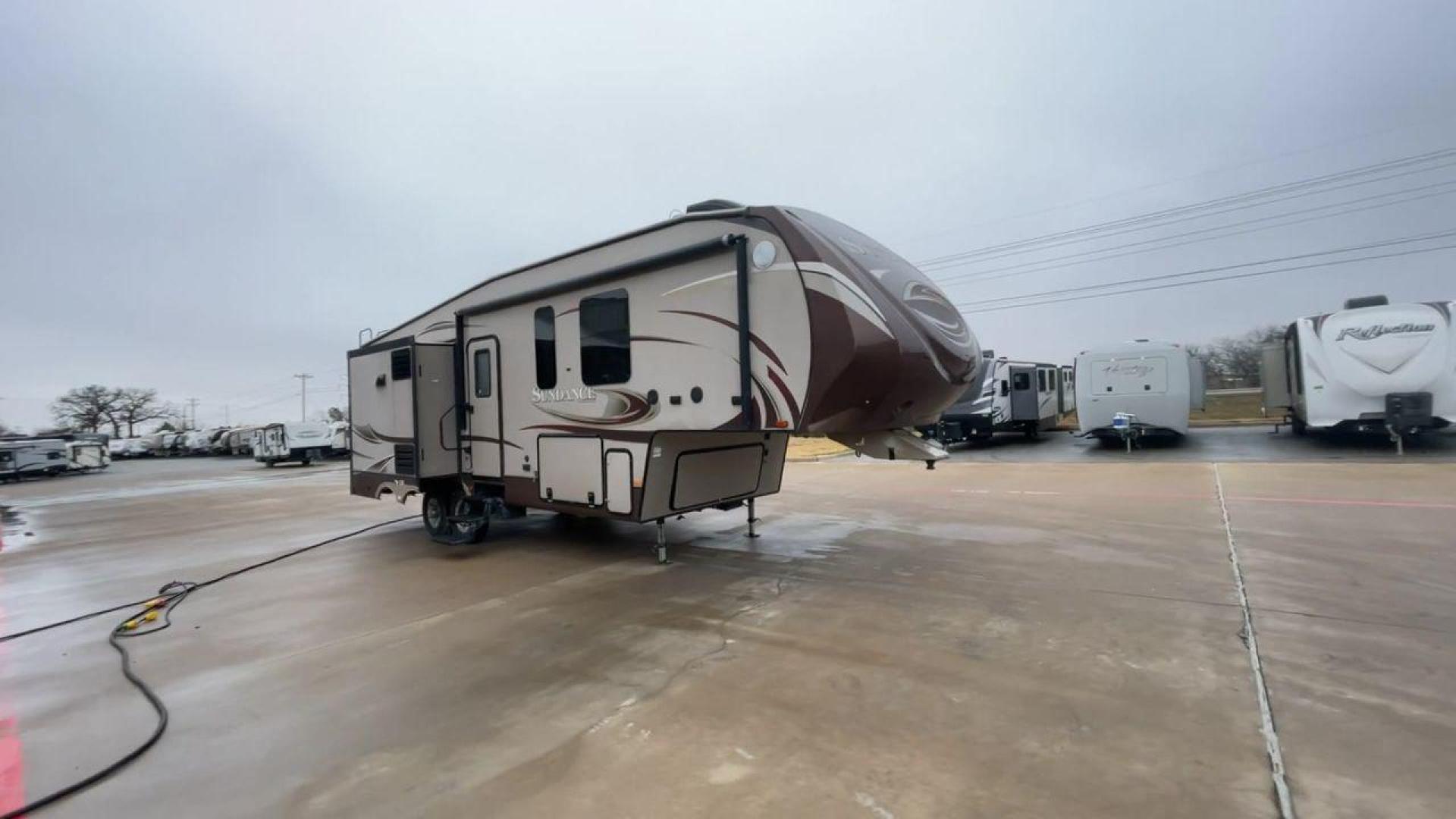 2014 TAN SUNDANCE 2880RLT (5SFSG3320EE) , Length: 32.2 ft. | Dry Weight: 9,750 lbs. | Gross Weight: 13,800 lbs. | Slides: 3 transmission, located at 4319 N Main St, Cleburne, TX, 76033, (817) 678-5133, 32.385960, -97.391212 - This 2014 Sundance Fifth Wheel is just over 32 feet long and 8 feet wide. It has a GVWR of 13,800 lbs and a hitch weight of 2,220 lbs. The exterior of this fifth wheel is a stylish grey with brown, white, and beige decals. This model also has three slides and a 16-foot power-retractable awning. The - Photo#3