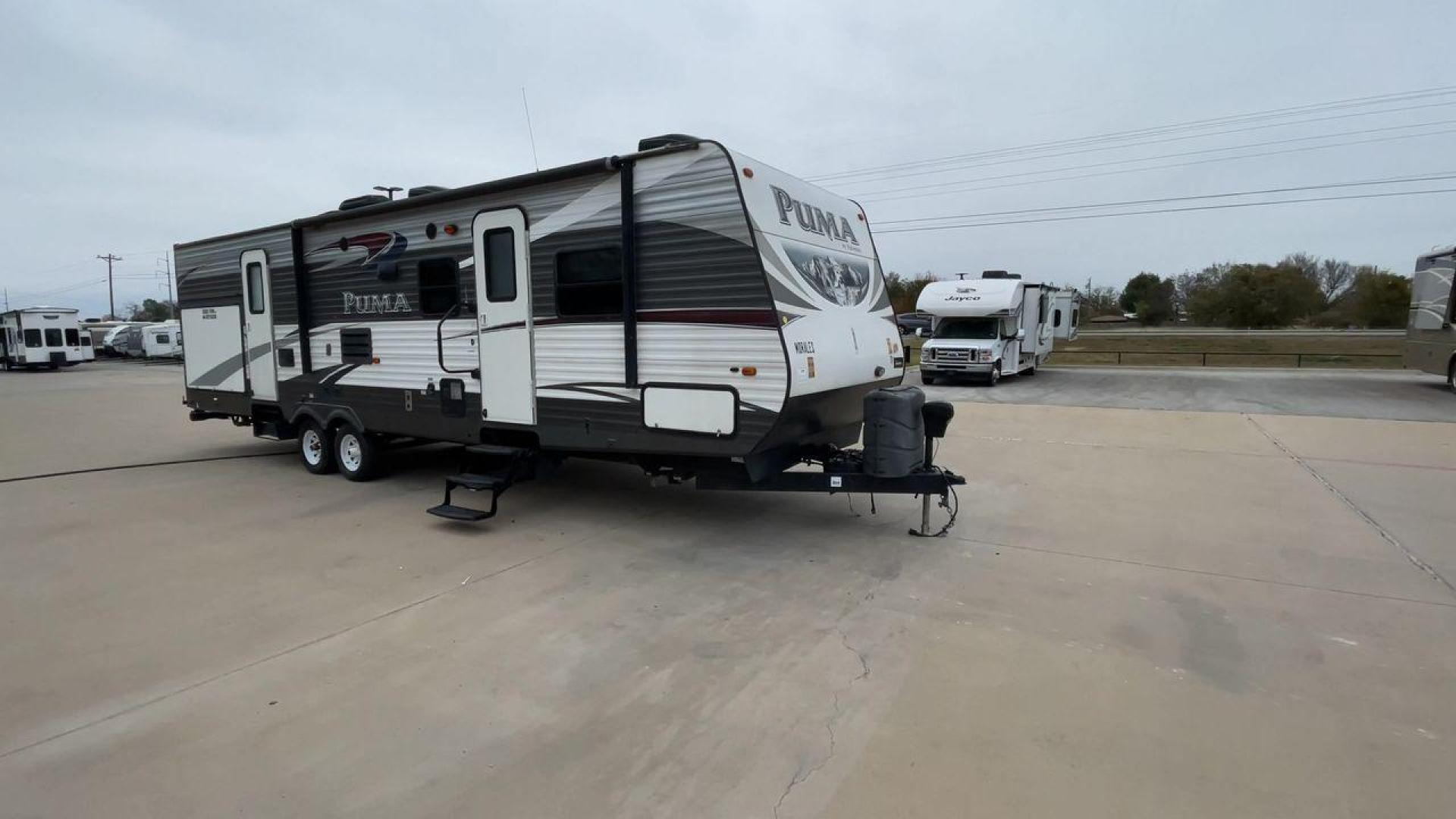 2015 FOREST RIVER PUMA 31BHSS (4X4TPUG21FP) , Length: 35.33 ft. | Dry Weight: 7,702 lbs. | Gross Weight: 10,236 lbs. | Slides: 2 transmission, located at 4319 N Main St, Cleburne, TX, 76033, (817) 678-5133, 32.385960, -97.391212 - The 2015 Forest River Puma 31BH RV features a classic and durable exterior design. The body of the RV is a combination of gray, white, and black with accents of maroon, which gives it a rugged yet stylish look. The sides have aluminum panels with a ribbed texture, which not only adds to the aestheti - Photo#3