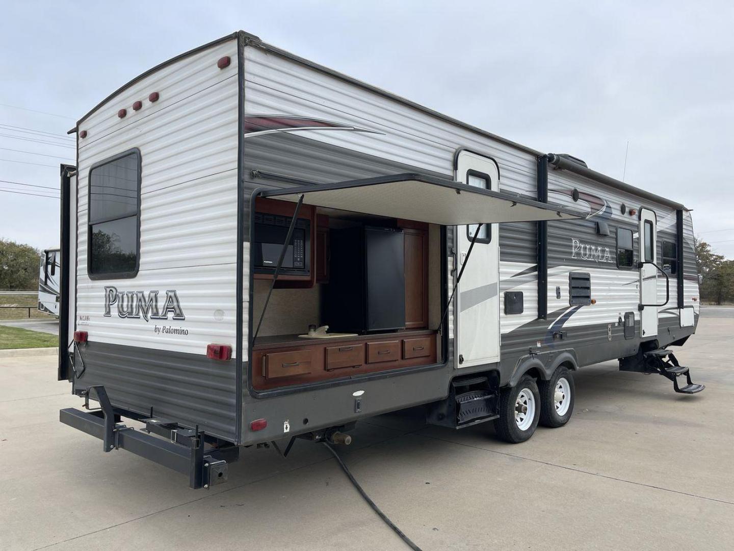 2015 FOREST RIVER PUMA 31BHSS (4X4TPUG21FP) , Length: 35.33 ft. | Dry Weight: 7,702 lbs. | Gross Weight: 10,236 lbs. | Slides: 2 transmission, located at 4319 N Main St, Cleburne, TX, 76033, (817) 678-5133, 32.385960, -97.391212 - The 2015 Forest River Puma 31BH RV features a classic and durable exterior design. The body of the RV is a combination of gray, white, and black with accents of maroon, which gives it a rugged yet stylish look. The sides have aluminum panels with a ribbed texture, which not only adds to the aestheti - Photo#25