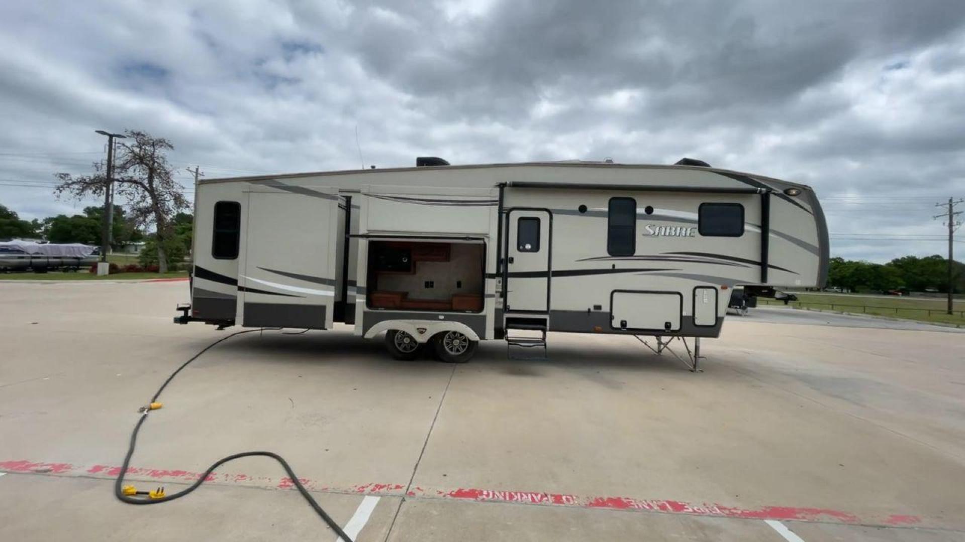 2015 TAN PALOMINO SABRE 34RDKS (4X4FSRK2XF3) , Length: 38.92 ft. | Dry Weight: 11,081 lbs. | Gross Weight: 13,950 lbs. | Slides: 4 transmission, located at 4319 N Main St, Cleburne, TX, 76033, (817) 678-5133, 32.385960, -97.391212 - This 2015 Sabre Fifth Wheel measures at just under 39 feet with a dry weight of 11,081 lbs. It has a GVWR of 13,950 lbs and a hitch weight of 2,205 lbs. This unit has a heater rated at 35,000 BTUs and a cooler rated at 13,500 BTUs meaning the temperature is always in your control. This model has a b - Photo#2