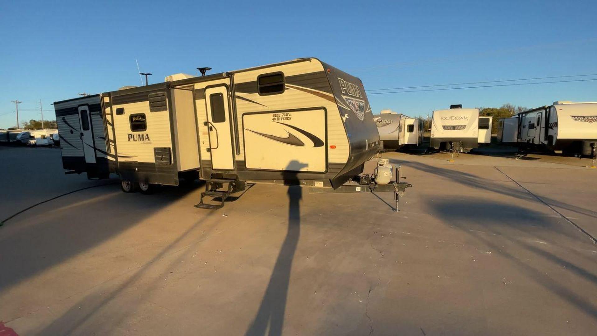 2016 TAN PUMA 32FBIS (4X4TPUH21GP) , Length: 35.33 ft. | Dry Weight: 8,858 lbs. | Gross Weight: 10,500 lbs. | Slides: 3 transmission, located at 4319 N Main St, Cleburne, TX, 76033, (817) 678-5133, 32.385960, -97.391212 - The 2016 Puma 32FBIS travel trailer boasts a classic yet robust exterior that embodies convenience and practicality for family trips and long getaways. The travel trailer features aluminum siding in a silver tone, accentuated with subtle brown and black graphic designs that add a sleek, modern touch - Photo#3