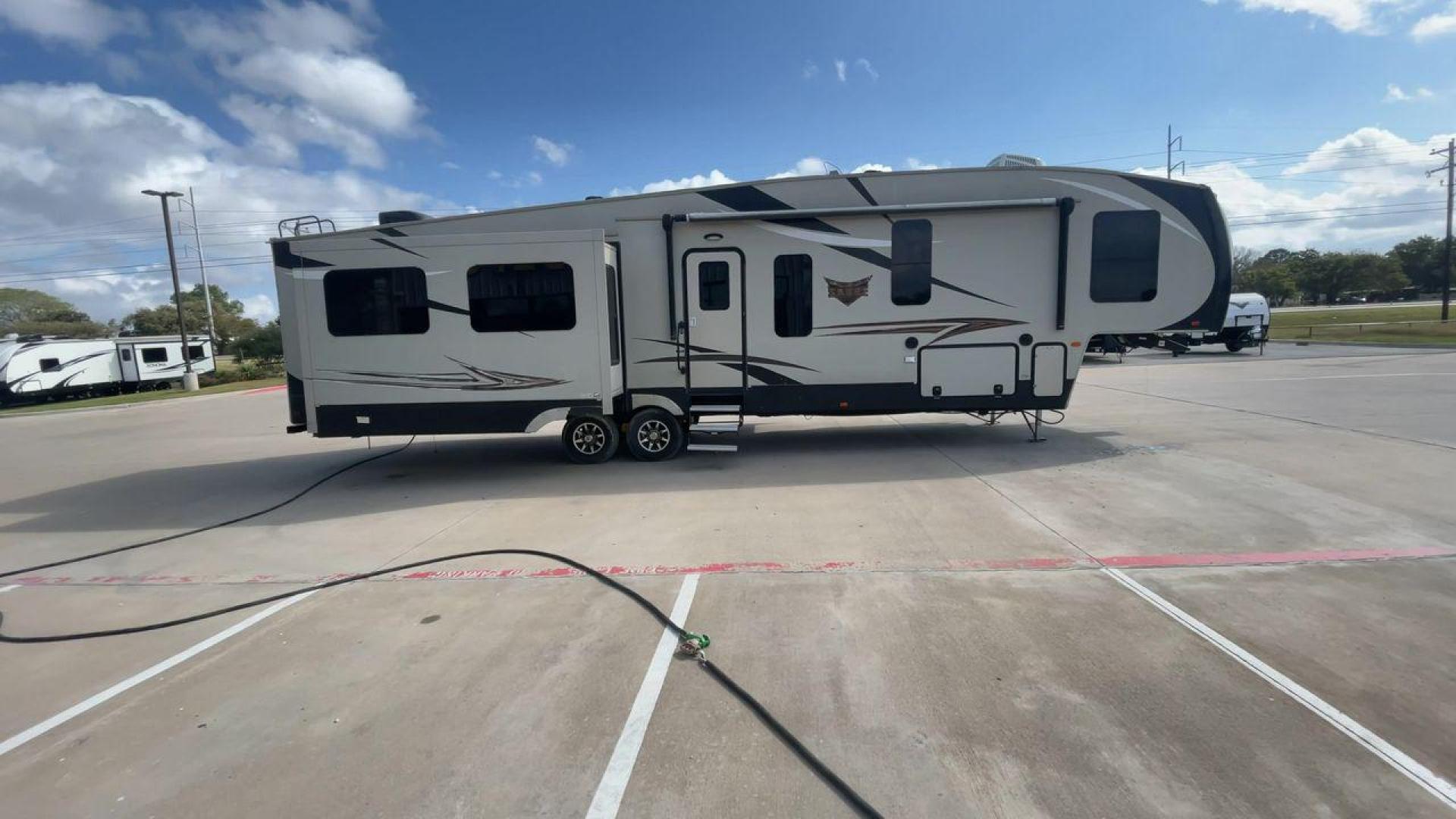 2016 TAN SABRE 365MB (4X4FSRN29G3) , Length: 42.42 ft. | Dry Weight: 12,994 lbs. | Gross Weight: 15,500 lbs. | Slides: 4 transmission, located at 4319 N Main St, Cleburne, TX, 76033, (817) 678-5133, 32.385960, -97.391212 - The 2016 Sabre 365MB Fifth Wheel stretches 42.42 feet in length, with a commanding presence on the road and at the campground. The exterior is finished in a beige and black color scheme, accented with bold swooping graphics that add an athletic flair to its overall look. The side profile features fo - Photo#2