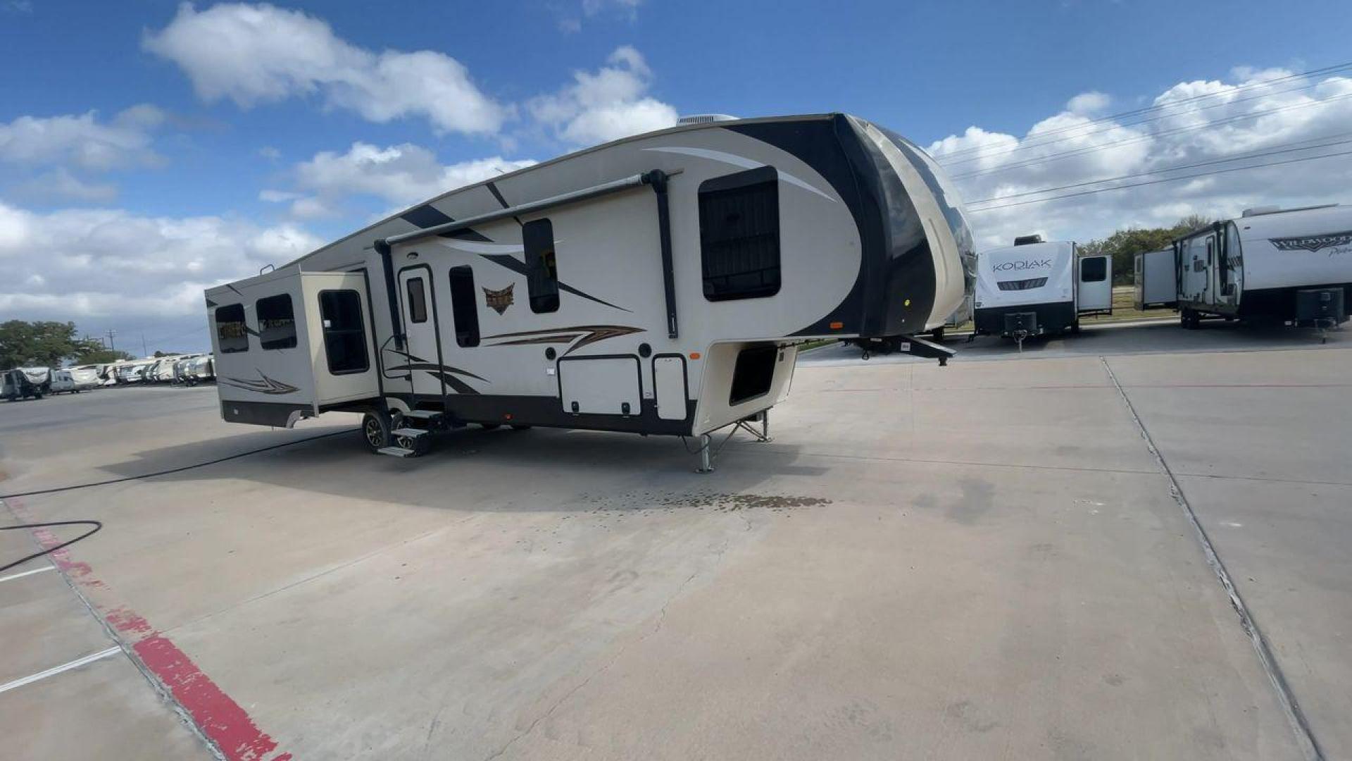 2016 TAN SABRE 365MB (4X4FSRN29G3) , Length: 42.42 ft. | Dry Weight: 12,994 lbs. | Gross Weight: 15,500 lbs. | Slides: 4 transmission, located at 4319 N Main St, Cleburne, TX, 76033, (817) 678-5133, 32.385960, -97.391212 - The 2016 Sabre 365MB Fifth Wheel stretches 42.42 feet in length, with a commanding presence on the road and at the campground. The exterior is finished in a beige and black color scheme, accented with bold swooping graphics that add an athletic flair to its overall look. The side profile features fo - Photo#3