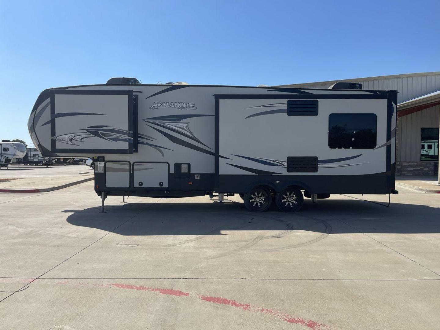 2017 GRAY KEYSTONE AVALANCHE 300RE (4YDF30028HE) , Length: 34.5 ft. | Dry Weight: 11,489 lbs. | Gross Weight: 15,000 lbs. | Slides: 3 transmission, located at 4319 N Main St, Cleburne, TX, 76033, (817) 678-5133, 32.385960, -97.391212 - The 2017 Keystone Avalanche 300RE is a dual-axle aluminum wheel setup measuring 34.5 ft. in length. It has a dry weight of 11,489 lbs. and a GVWR of 15,000 lbs. Its exterior is a base color of silver with black, gray, and white graphics. It is made of aluminum and fiberglass. With 3 slides, it is ro - Photo#23