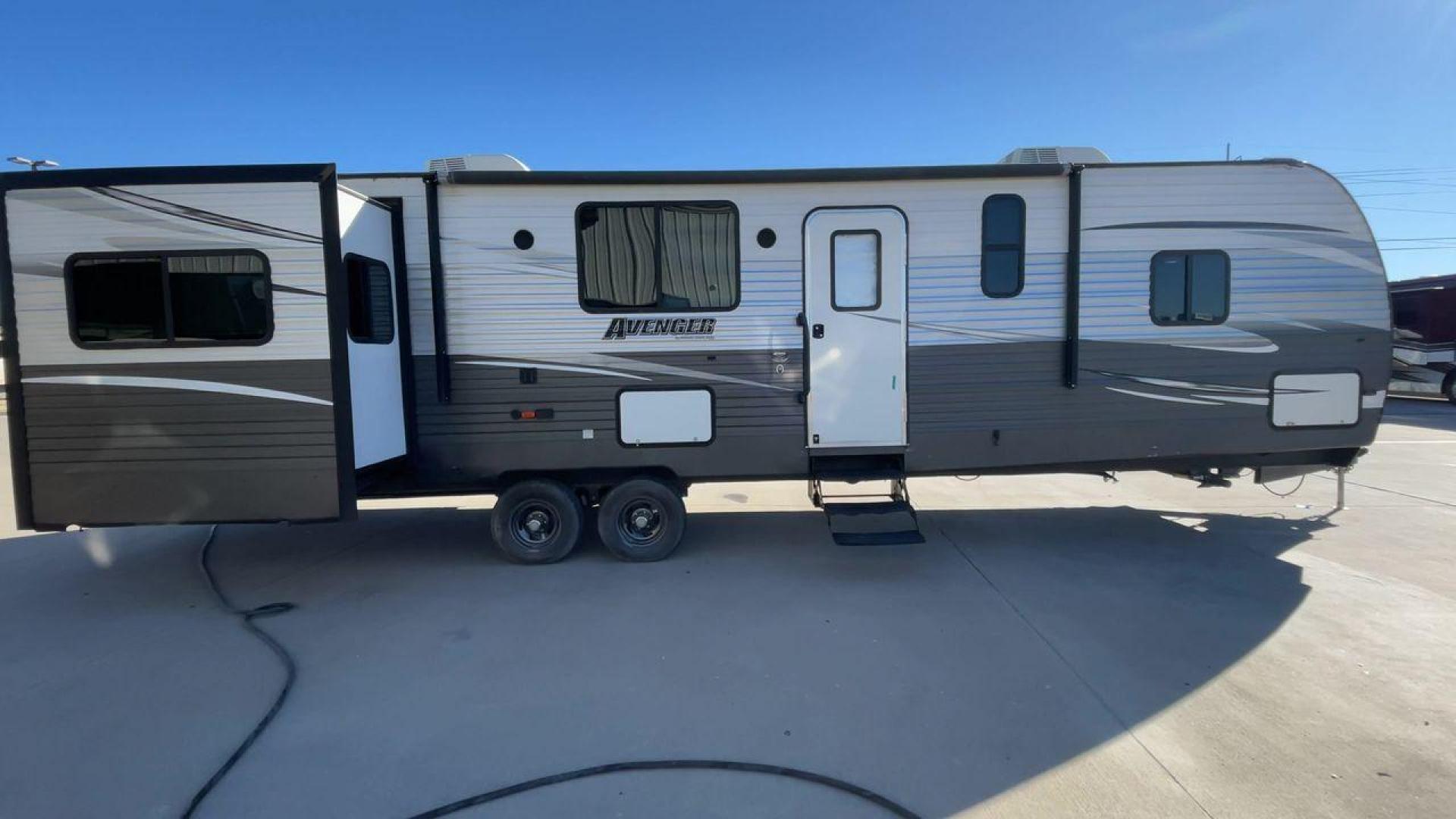 2019 TAN FOREST RIVER AVENGER 32DEN (5ZT2AVXB6KB) , Length: 37.92 ft. | Dry Weight: 7,989 lbs. | Slides: 2 transmission, located at 4319 N Main St, Cleburne, TX, 76033, (817) 678-5133, 32.385960, -97.391212 - Measuring an impressive 36 feet, this model unfolds to reveal two strategically placed slide-outs, creating a spacious haven for relaxation. The master bedroom welcomes you with a queen-size bed and ample storage, ensuring a peaceful retreat after a day of outdoor exploration. The living area is a h - Photo#2