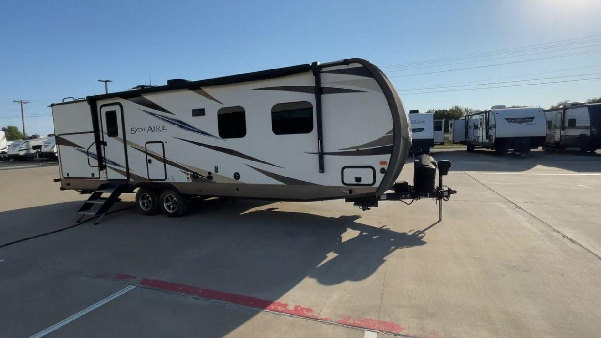 2019 TAN FOREST RIVER SOLAIRE 258RBSS (4X4TPAB24KN) , Length: 32.67 ft. | Dry Weight: 6,398 lbs. | Gross Weight: 7,765 lbs. | Slides: 1 transmission, located at 4319 N Main St, Cleburne, TX, 76033, (817) 678-5133, 32.385960, -97.391212 - The 2019 Palomino Solaire 258RBSS Travel Trailer combines style with functionality. Measuring 32.67 feet in length, this unit features a single slide-out, which provides additional interior space. The white and gray body is accented with dynamic graphics, offering a contemporary look. The front show - Photo#3