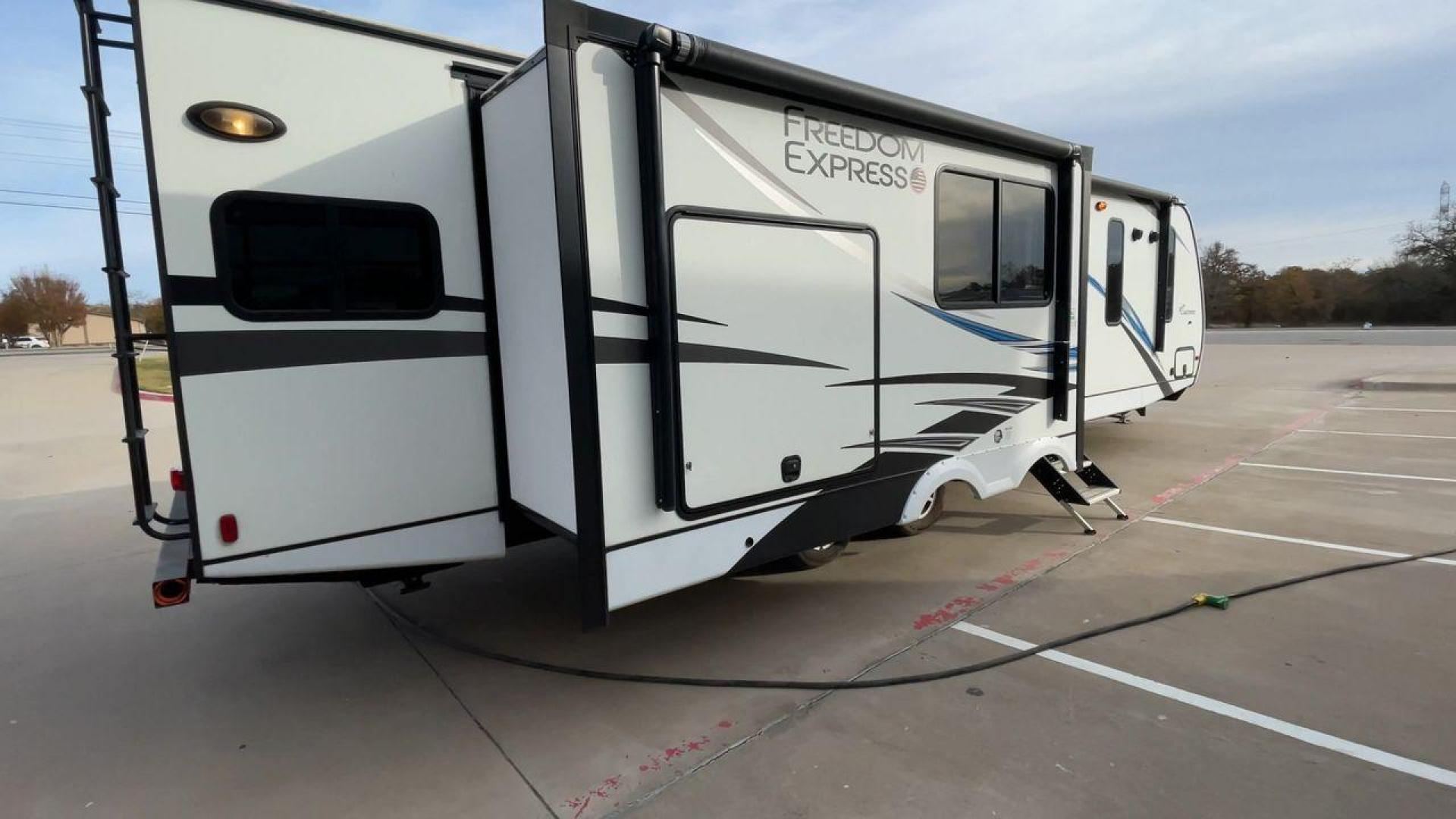 2020 FOREST RIVER FREEDOM EXPRESS (5ZT2FEXBXLW) , Length: 36.92 ft | Dry Weight: 8,328 lbs | Gross Weight: 10,500 lbs | Slides: 3 transmission, located at 4319 N Main St, Cleburne, TX, 76033, (817) 678-5133, 32.385960, -97.391212 - The 2020 Freedom Express 324RLDS has a white body accented with sleek black and blue graphics, creating a stylish look. The front cap features an aerodynamic shape with bold design lines and a large tinted window. A sturdy electric tongue jack is positioned at the hitch for easy adjustments, complem - Photo#1