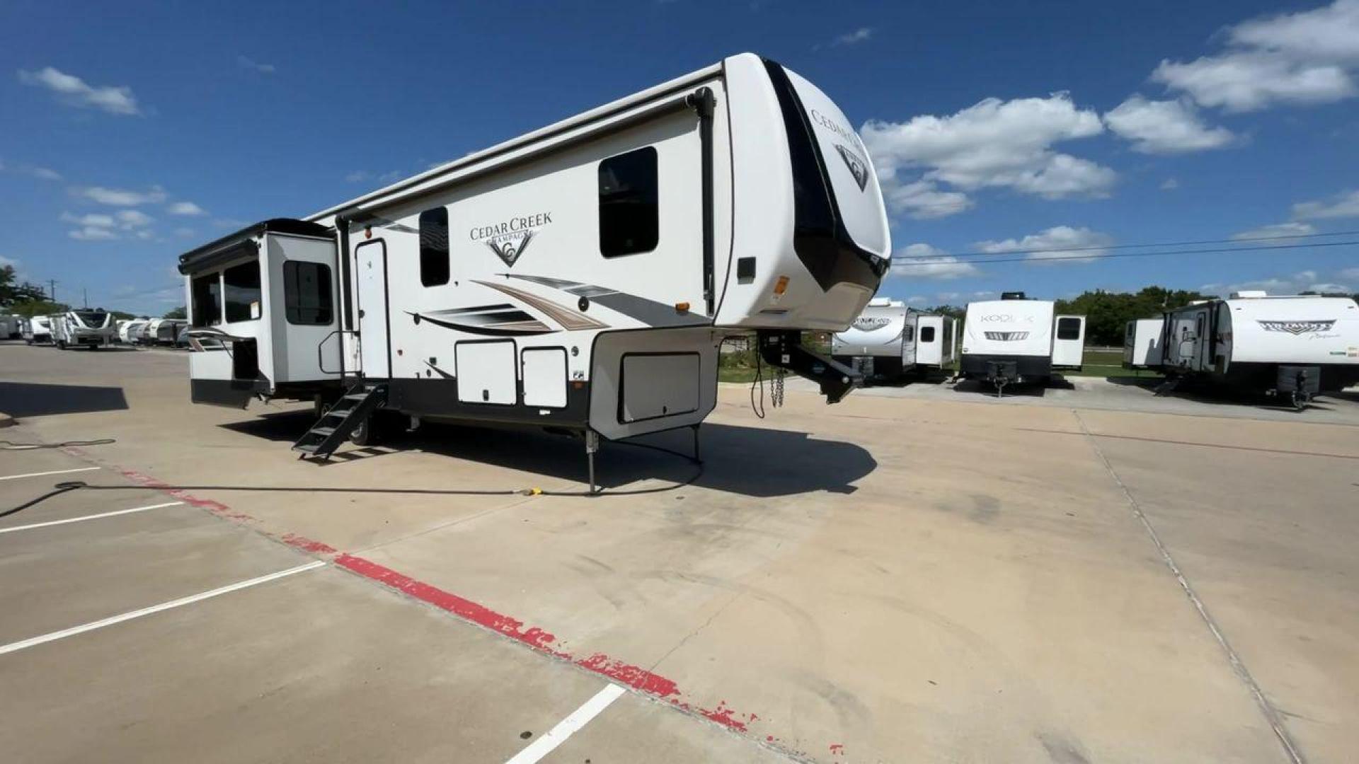 2021 FOREST RIVER CEDAR CREEK 38EL (4X4FCRP25MS) , Length: 39.75 ft. | Dry Weight: 14,429 lbs. | Gross Weight: 18,000 lbs. | Slides: 3 transmission, located at 4319 N Main St, Cleburne, TX, 76033, (817) 678-5133, 32.385960, -97.391212 - The 2021 Forest River Cedar Creek 38EL Champagne offers luxury and space for your next adventure. With a length of 39.75 feet and a dry weight of 14,429 lbs., this RV boasts three spacious slides to maximize living space. The exterior features sleek lines with large windows and a ladder at the rear, - Photo#3