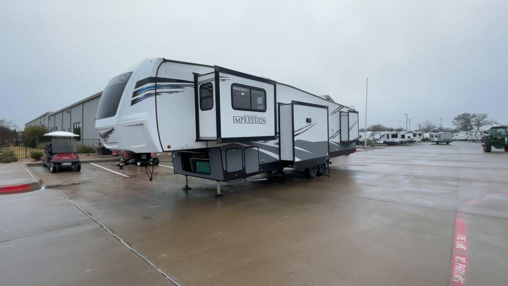 2021 FOREST RIVER IMPRESSION 320FL (5ZT3MPXB1MD) , Length: 40.17 ft | Dry Weight: 10,303 lbs | Gross Weight: 14,535 lbs | Slides: 4 transmission, located at 4319 N Main St, Cleburne, TX, 76033, (817) 678-5133, 32.385960, -97.391212 - The 2021 Forest River Impression 320FL fifth wheel RV is built for durability and style. Its sleek white fiberglass body is accented with bold black and blue graphics, giving it a modern and aerodynamic look. The front cap features a distinctive aerodynamic profile with the Impression logo prominent - Photo#5