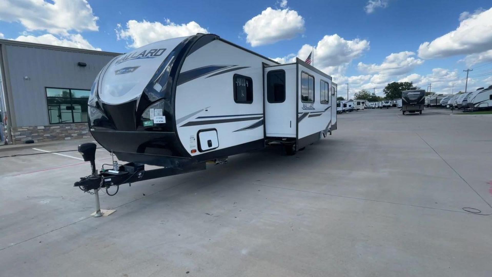 2021 HEARTLAND MALLARD M32 (5SFNB3524ME) , Length: 34.79 ft. | Dry Weight: 6,926 lbs. | Gross Weight: 8,600 lbs. | Slides: 2 transmission, located at 4319 N Main St, Cleburne, TX, 76033, (817) 678-5133, 32.385960, -97.391212 - The 2021 Heartland Mallard M32 is a sleek and modern travel trailer with a length of 34.79 feet and a dry weight of 6,926 lbs. The gross weight is 8,600 lbs, making it easily towable by larger SUVs and trucks. It features a clean, white exterior with stylish blue and black decals that run along the - Photo#5