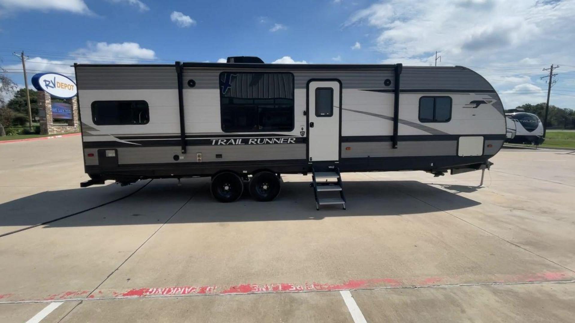 2021 HEARTLAND TRAIL RUNNER 27RKS (5SFEB3423ME) , Length: 32.1 ft. | Dry Weight: 6,392 lbs | Gross Weight: 9,574 lbs | Slides: 1 transmission, located at 4319 N Main St, Cleburne, TX, 76033, (817) 678-5133, 32.385960, -97.391212 - The 2021 Heartland Trail Runner 27RKS has a modern design with a length of 32.1 feet. The exterior is outfitted in a combination of silver, gray, and black, with sharp geometric accents that give it a sporty appearance. The front cap features a sloped, aerodynamic shape with Trail Runner branding. T - Photo#1