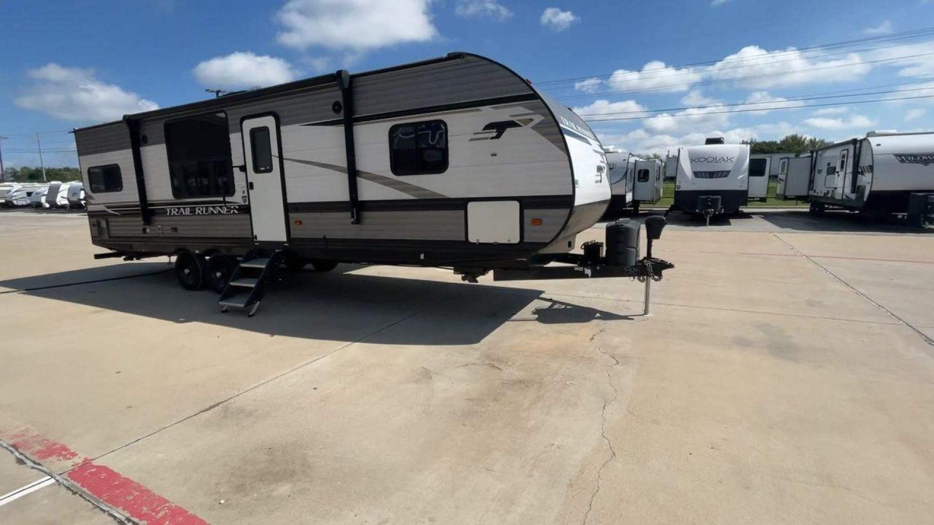 2021 HEARTLAND TRAIL RUNNER 27RKS (5SFEB3423ME) , Length: 32.1 ft. | Dry Weight: 6,392 lbs | Gross Weight: 9,574 lbs | Slides: 1 transmission, located at 4319 N Main St, Cleburne, TX, 76033, (817) 678-5133, 32.385960, -97.391212 - The 2021 Heartland Trail Runner 27RKS has a modern design with a length of 32.1 feet. The exterior is outfitted in a combination of silver, gray, and black, with sharp geometric accents that give it a sporty appearance. The front cap features a sloped, aerodynamic shape with Trail Runner branding. T - Photo#2