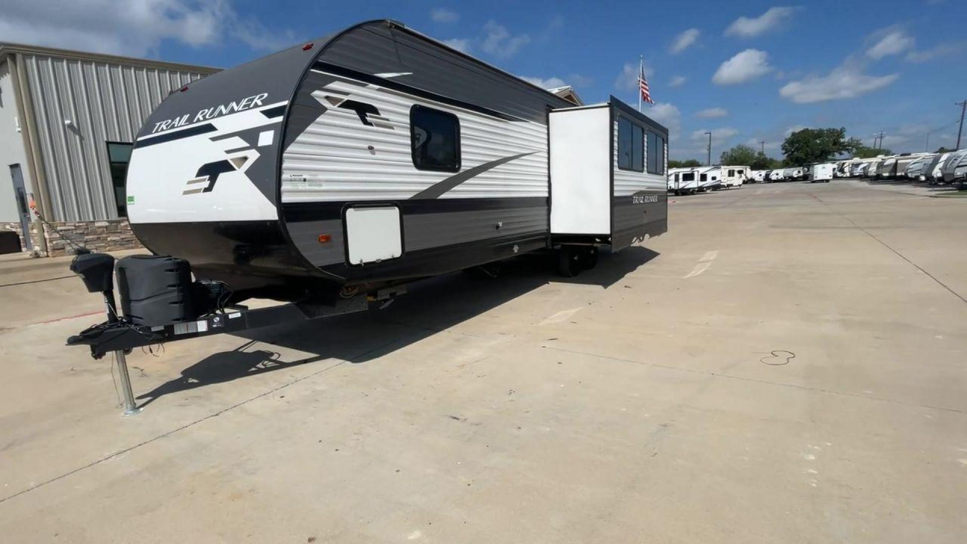 2021 HEARTLAND TRAIL RUNNER 27RKS (5SFEB3423ME) , Length: 32.1 ft. | Dry Weight: 6,392 lbs | Gross Weight: 9,574 lbs | Slides: 1 transmission, located at 4319 N Main St, Cleburne, TX, 76033, (817) 678-5133, 32.385960, -97.391212 - The 2021 Heartland Trail Runner 27RKS has a modern design with a length of 32.1 feet. The exterior is outfitted in a combination of silver, gray, and black, with sharp geometric accents that give it a sporty appearance. The front cap features a sloped, aerodynamic shape with Trail Runner branding. T - Photo#4