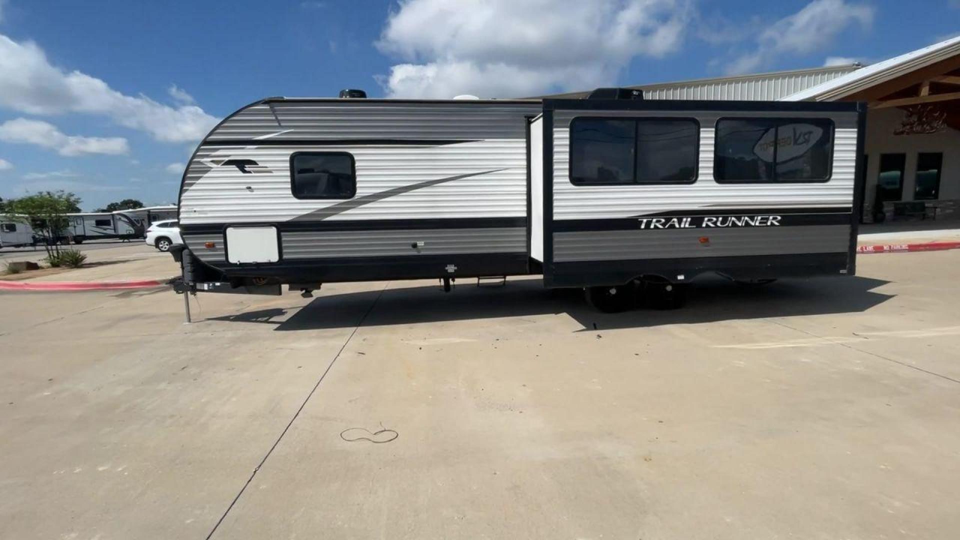 2021 HEARTLAND TRAIL RUNNER 27RKS (5SFEB3423ME) , Length: 32.1 ft. | Dry Weight: 6,392 lbs | Gross Weight: 9,574 lbs | Slides: 1 transmission, located at 4319 N Main St, Cleburne, TX, 76033, (817) 678-5133, 32.385960, -97.391212 - The 2021 Heartland Trail Runner 27RKS has a modern design with a length of 32.1 feet. The exterior is outfitted in a combination of silver, gray, and black, with sharp geometric accents that give it a sporty appearance. The front cap features a sloped, aerodynamic shape with Trail Runner branding. T - Photo#5