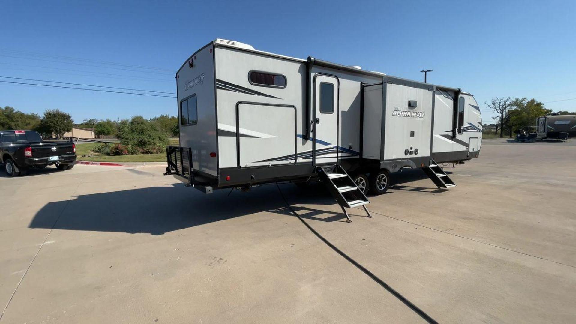 2022 FOREST RIVER CHEROKEE 33BH-L (5ZT2CKYBXN2) , Length: 37.33 ft. | Dry Weight: 7,986 lbs. | Gross Weight: 9,863 lbs. | Slides: 2 transmission, located at 4319 N Main St, Cleburne, TX, 76033, (817) 678-5133, 32.385960, -97.391212 - The 2022 Forest River Cherokee Alpha Wolf 33BH-L showcases a modern and sleek exterior which is perfectly built for extended road adventures. Measuring 37.33 feet in length, it features a two-tone gray and black color scheme with sharp, angular graphics that give it a contemporary, aggressive look. - Photo#1