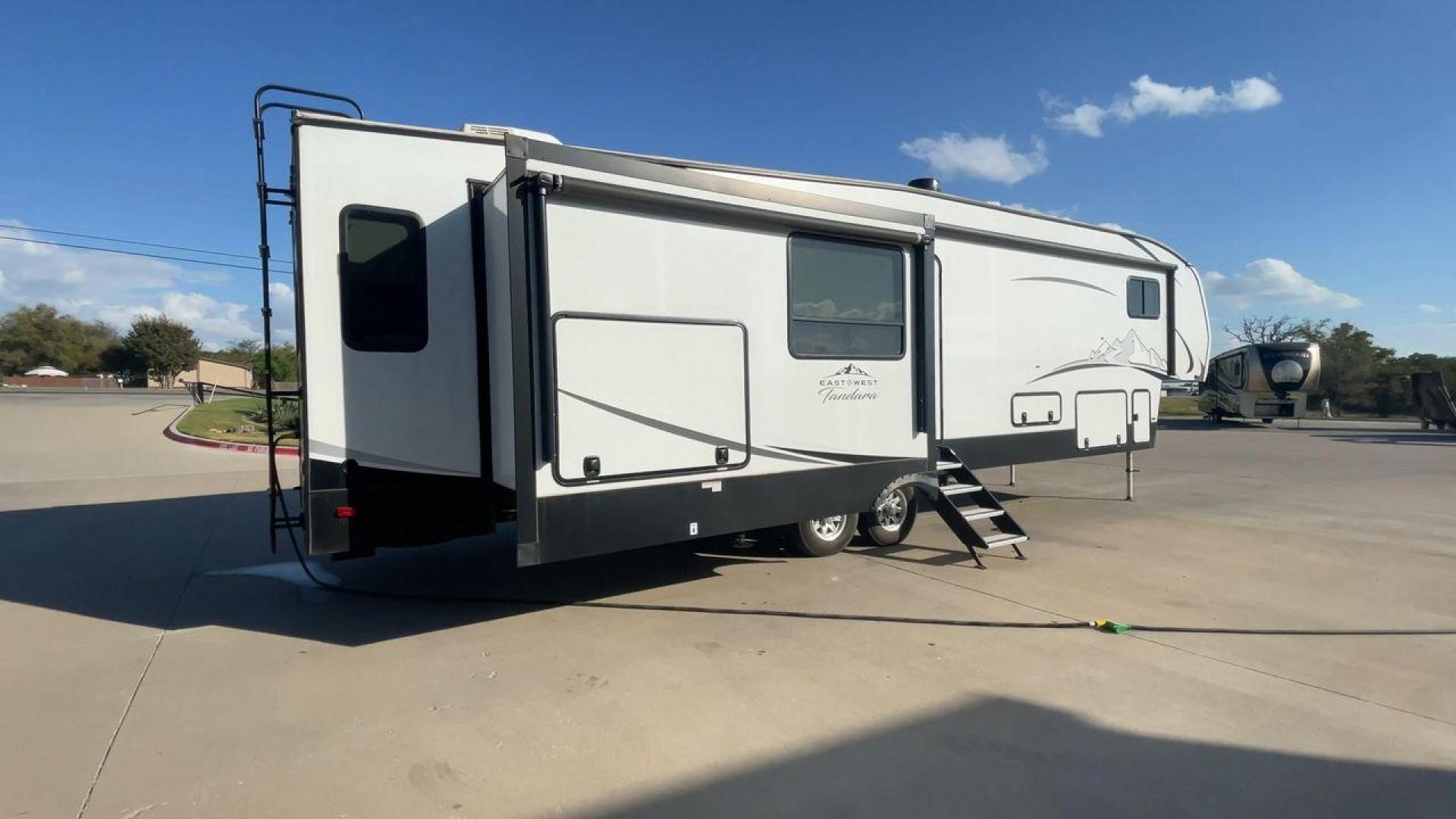 2022 FOREST RIVER EAST TO WEST TANDARA (5ZT3TD4B6N9) , Length: 41.25 ft | Dry Weight: 13,179 lbs | Slides: 4 transmission, located at 4319 N Main St, Cleburne, TX, 76033, (817) 678-5133, 32.385960, -97.391212 - At 41.25 ft. long, the front cap showcases a bold "East to West Tandara" logo, accentuated by clean, aerodynamic curves. Large, tinted windows provide natural light while maintaining privacy. Four (4) slideouts expand the living space, enhancing functionality when parked. The trailer is equipped wit - Photo#1