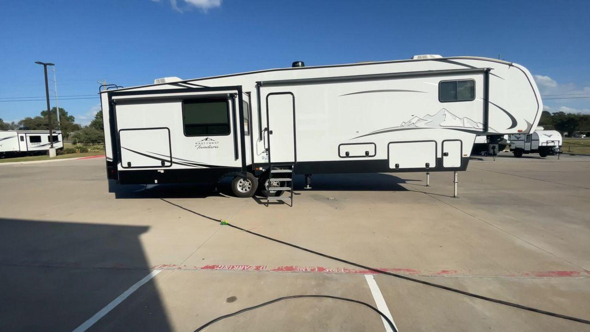 2022 FOREST RIVER EAST TO WEST TANDARA (5ZT3TD4B6N9) , Length: 41.25 ft | Dry Weight: 13,179 lbs | Slides: 4 transmission, located at 4319 N Main St, Cleburne, TX, 76033, (817) 678-5133, 32.385960, -97.391212 - At 41.25 ft. long, the front cap showcases a bold "East to West Tandara" logo, accentuated by clean, aerodynamic curves. Large, tinted windows provide natural light while maintaining privacy. Four (4) slideouts expand the living space, enhancing functionality when parked. The trailer is equipped wit - Photo#2