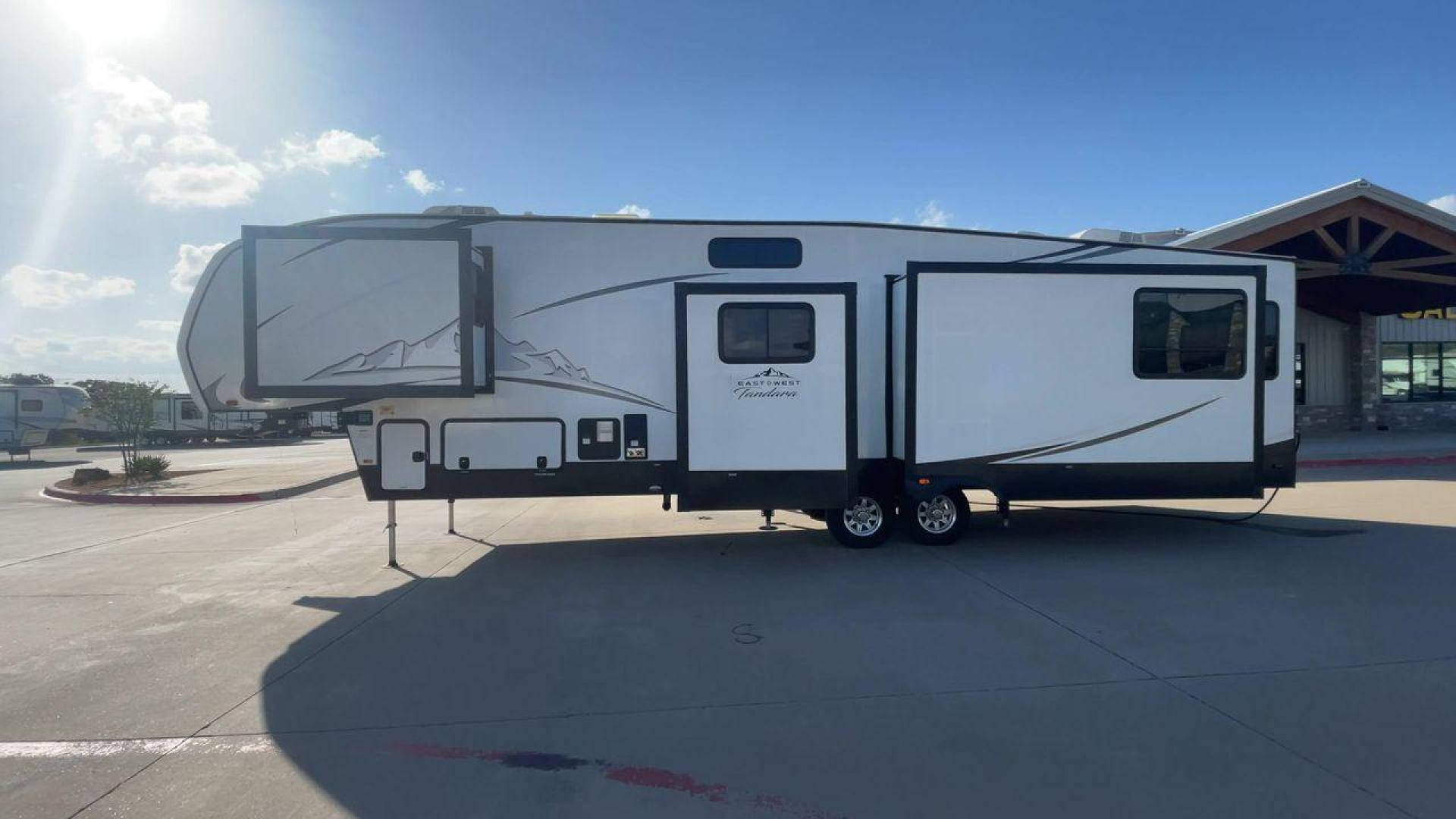 2022 FOREST RIVER EAST TO WEST TANDARA (5ZT3TD4B6N9) , Length: 41.25 ft | Dry Weight: 13,179 lbs | Slides: 4 transmission, located at 4319 N Main St, Cleburne, TX, 76033, (817) 678-5133, 32.385960, -97.391212 - At 41.25 ft. long, the front cap showcases a bold "East to West Tandara" logo, accentuated by clean, aerodynamic curves. Large, tinted windows provide natural light while maintaining privacy. Four (4) slideouts expand the living space, enhancing functionality when parked. The trailer is equipped wit - Photo#6