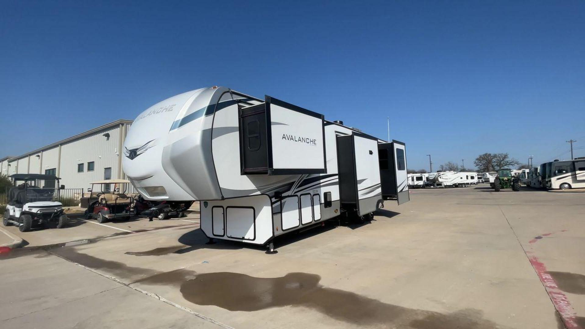 2022 KEYSTONE AVALANCHE 338GK (4YDFAVS24NE) , Length: 38 ft | Dry Weight: 12,523 lbs | Gross Weight: 15,500 lbs | Slides: 4 transmission, located at 4319 N Main St, Cleburne, TX, 76033, (817) 678-5133, 32.385960, -97.391212 - The 2022 Keystone Avalanche 338GK showcases a sleek and modern exterior design, built for durability and style. This fifth wheel features a glossy white body accented by sharp, aerodynamic lines in subtle shades of gray and black, giving it a clean and contemporary look. The front cap is bold and ae - Photo#5