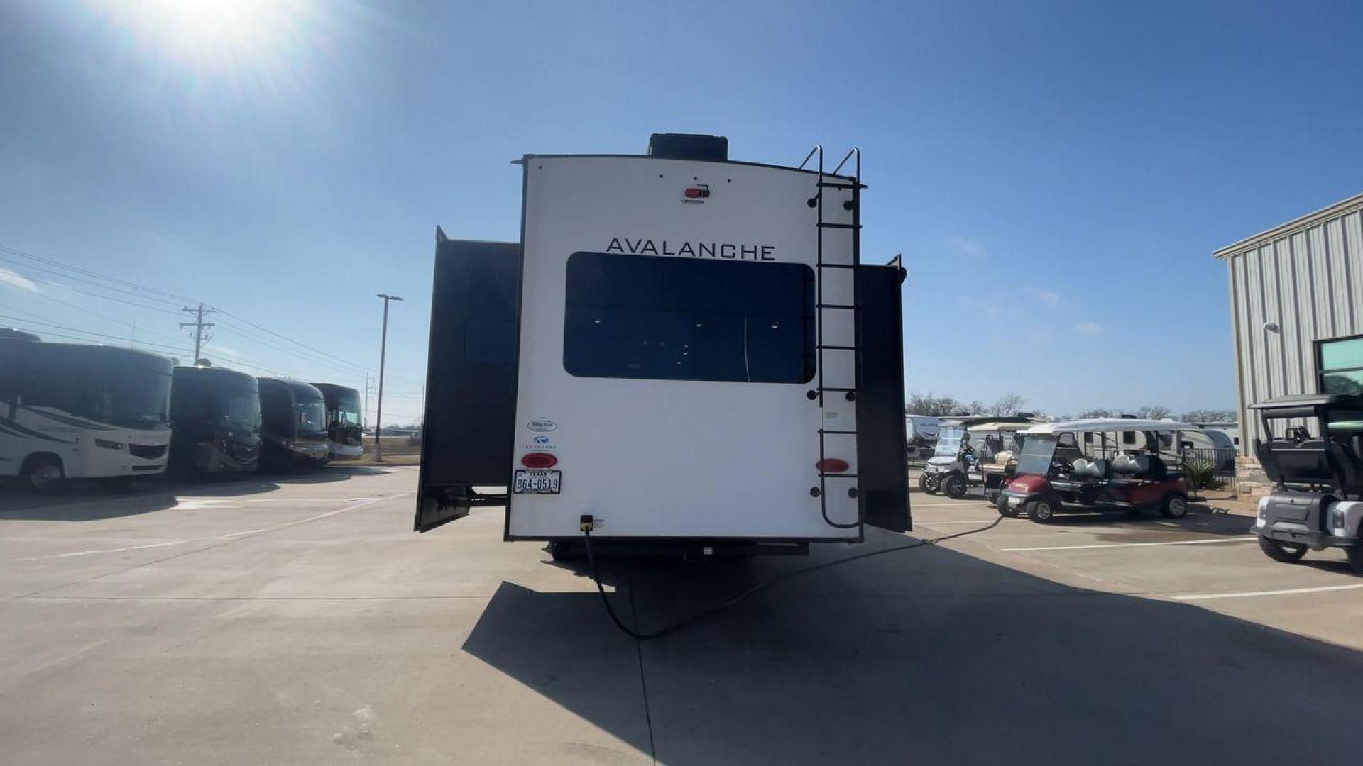 2022 KEYSTONE AVALANCHE 338GK (4YDFAVS24NE) , Length: 38 ft | Dry Weight: 12,523 lbs | Gross Weight: 15,500 lbs | Slides: 4 transmission, located at 4319 N Main St, Cleburne, TX, 76033, (817) 678-5133, 32.385960, -97.391212 - The 2022 Keystone Avalanche 338GK showcases a sleek and modern exterior design, built for durability and style. This fifth wheel features a glossy white body accented by sharp, aerodynamic lines in subtle shades of gray and black, giving it a clean and contemporary look. The front cap is bold and ae - Photo#8