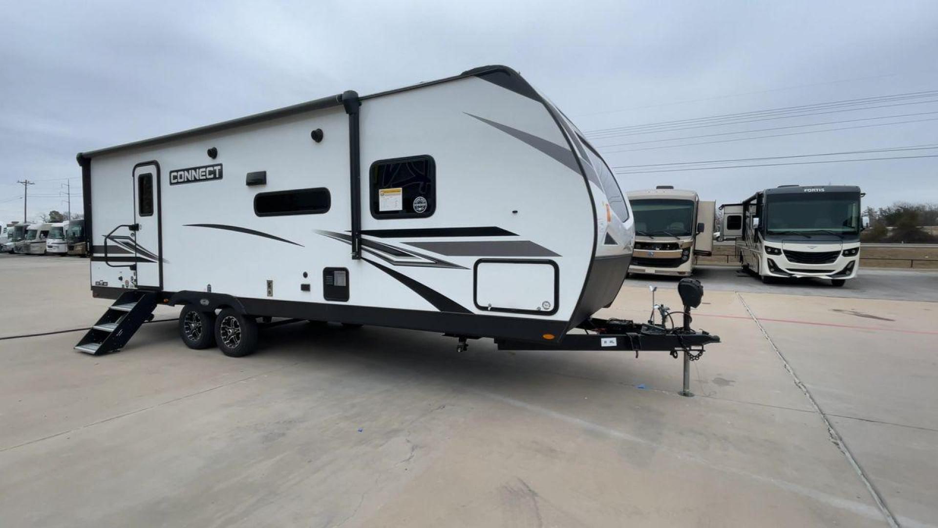 2024 KZ CONNECT 261RB (4EZTL2721R7) , Length: 30.33 ft | Dry Weight: 6,460 lbs | Gross Weight: 7,345 lbs | Slides: 1 transmission, located at 4319 N Main St, Cleburne, TX, 76033, (817) 678-5133, 32.385960, -97.391212 - At 30.33 ft long, the 2024 KZ Connect 261RB is a modern and stylish travel trailer with a sleek and aerodynamic design. Its white fiberglass exterior is accented with black and gray geometric decals, giving it a sharp and contemporary look. The front cap is painted black with the CONNECT branding pr - Photo#3